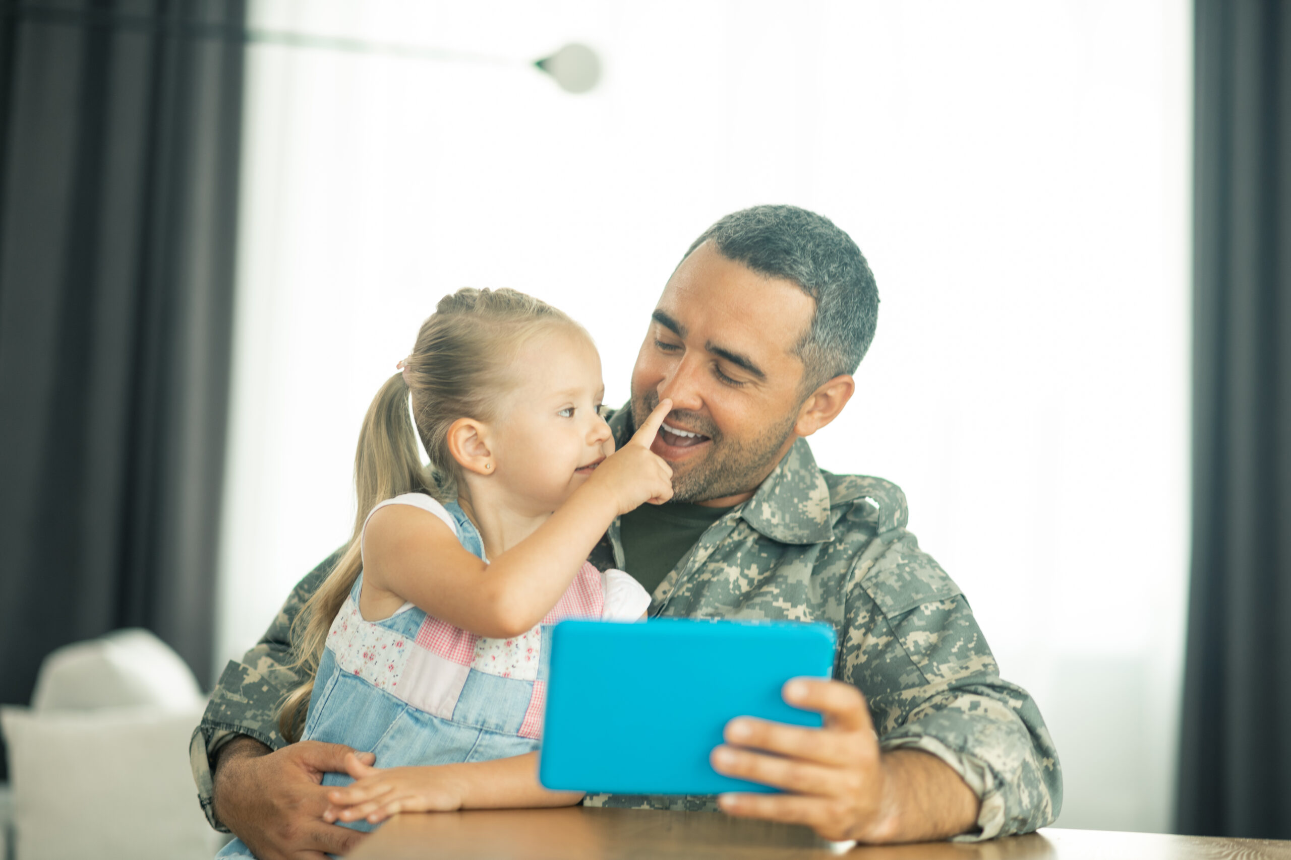 Man in army uniform with his daughter. Happy.
